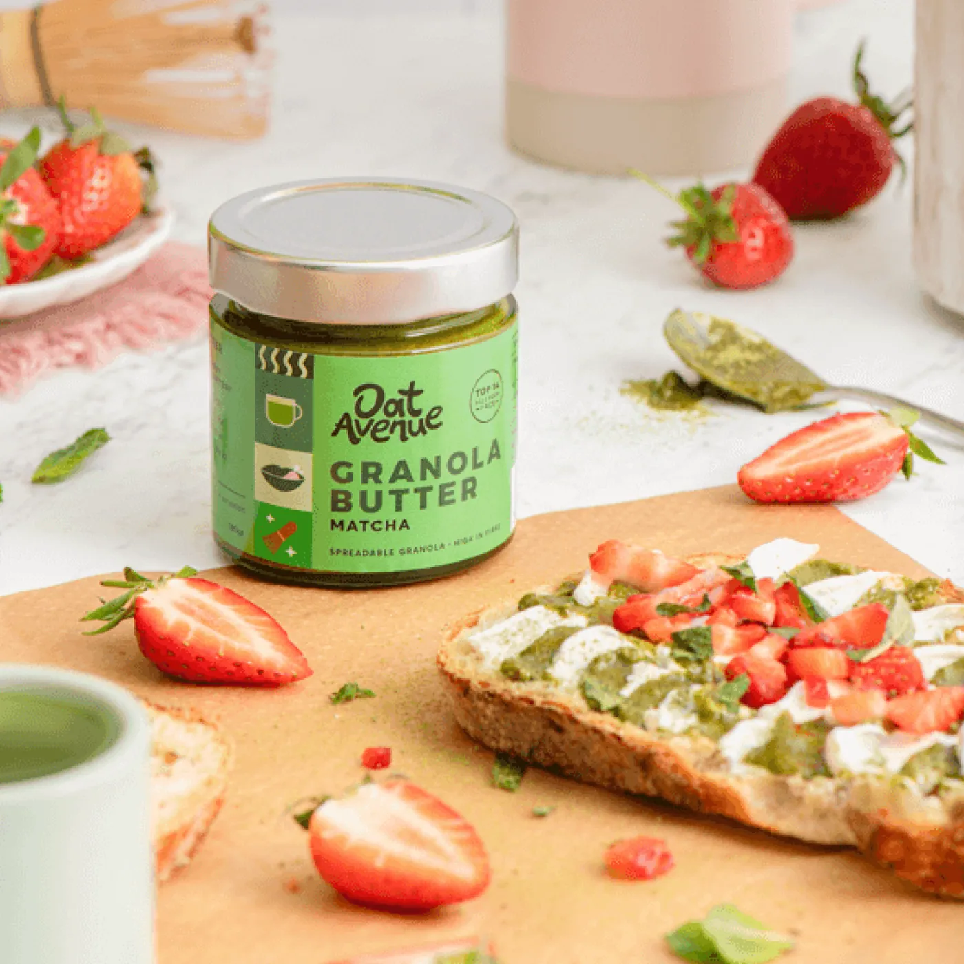 Matcha granola butter jar with fresh strawberries